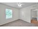 This bedroom features neutral carpet, a window, and an adjacent door at 32775 Brooks Hawk Ln, Wesley Chapel, FL 33543