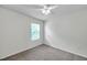 This bedroom features neutral carpet, a ceiling fan, and a bright window at 32775 Brooks Hawk Ln, Wesley Chapel, FL 33543