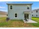 The back exterior features a patio with seating and lush green grass at 32775 Brooks Hawk Ln, Wesley Chapel, FL 33543