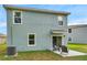 The back exterior features a patio with seating and lush green grass at 32775 Brooks Hawk Ln, Wesley Chapel, FL 33543