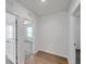 Hallway featuring wood floors, a ceiling fan in another room and white walls at 32775 Brooks Hawk Ln, Wesley Chapel, FL 33543