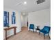 Bright hallway featuring wood floors, recessed lighting, and stylish decor with blue chairs and matching artwork at 32775 Brooks Hawk Ln, Wesley Chapel, FL 33543