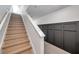 Well-lit stairway with wood stairs and a paneled accent wall offering an elegant transition between floors at 32775 Brooks Hawk Ln, Wesley Chapel, FL 33543