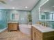 Remodeled bathroom with double wooden vanities, soaking tub, glass shower, led mirrors, and designer tile at 331 Cleveland St # 1806, Clearwater, FL 33755