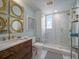 Modern bathroom featuring a marble shower, wooden vanity, and gold accents at 331 Cleveland St # 1806, Clearwater, FL 33755
