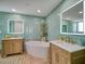 Spa-like bathroom boasts dual wooden vanities, soaking tub, led mirrors and unique hexagon tile at 331 Cleveland St # 1806, Clearwater, FL 33755