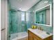 The renovated bathroom features a glass-enclosed shower, hexagon tile, a wooden vanity, and a LED mirror at 331 Cleveland St # 1806, Clearwater, FL 33755