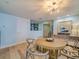 Light and airy dining area features a round wooden table, straw chairs, and modern light fixture at 331 Cleveland St # 1806, Clearwater, FL 33755