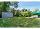 Large, green backyard with a shed, lounge chairs and mature palms at 3626 17Th N St, St Petersburg, FL 33713