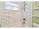 Close-up of bathroom subway tiles, tub and shower, brushed nickel hardware and storage at 3626 17Th N St, St Petersburg, FL 33713