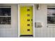 Close-up of a bright yellow front door with modern design elements and window at 3626 17Th N St, St Petersburg, FL 33713