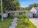 Charming single-story home features a vibrant yellow door, lush lawn, and inviting walkway at 3626 17Th N St, St Petersburg, FL 33713
