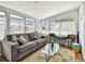 Bright sunroom with cozy seating area featuring a gray sofa and glass coffee table at 3626 17Th N St, St Petersburg, FL 33713