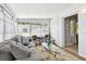 Sunroom with a comfortable gray sofa, glass table, and access to another room at 3626 17Th N St, St Petersburg, FL 33713
