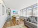 Light-filled sunroom features ample seating, large windows, and vibrant artwork of beach chairs at 3626 17Th N St, St Petersburg, FL 33713