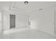 Bright bedroom featuring white walls, tray ceiling, and glossy white marble floors at 3803 E Curtis St, Tampa, FL 33610