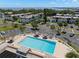 Stunning aerial view of a community pool with tiki huts surrounded by lush landscaping and a view of the bay at 381 S Mcmullen Booth Rd # 72, Clearwater, FL 33759