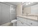 Bathroom with granite vanity top, white cabinets, and a glass-enclosed shower at 381 S Mcmullen Booth Rd # 72, Clearwater, FL 33759