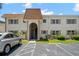 Condo building with brown roof and stairs leading to units, surrounded by landscaping at 381 S Mcmullen Booth Rd # 72, Clearwater, FL 33759