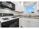 Bright kitchen with white cabinets, granite countertops, and modern appliances at 381 S Mcmullen Booth Rd # 72, Clearwater, FL 33759
