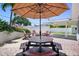 Charming backyard with a picnic table, fire pit, and seating shaded by a striped umbrella, perfect for outdoor dining at 430 44Th Ne Ave, St Petersburg, FL 33703