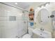 Updated bathroom featuring a glass shower door, white tile and a pedestal sink at 430 44Th Ne Ave, St Petersburg, FL 33703