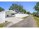 Long driveway leading to a backyard with covered parking, and storage shed, all surrounded by a privacy fence at 430 44Th Ne Ave, St Petersburg, FL 33703