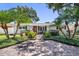 Inviting single-story home showcasing well-maintained landscaping, palm trees, and a brick paved driveway at 430 44Th Ne Ave, St Petersburg, FL 33703