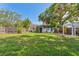 Secluded backyard featuring green lawn and mature trees, offering a private outdoor space at 433 San Salvador Dr, Dunedin, FL 34698