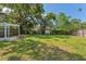 Expansive backyard featuring a fire pit, pergola, and lush greenery, perfect for outdoor enjoyment at 433 San Salvador Dr, Dunedin, FL 34698