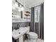 This bathroom features a pedestal sink, floating wood shelves, and decorative wallpaper at 433 San Salvador Dr, Dunedin, FL 34698