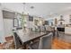Elegant dining room with stylish gray chairs, wooden floors, and open flow to the kitchen area at 433 San Salvador Dr, Dunedin, FL 34698