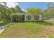 Charming single-story home with a well-manicured lawn and an inviting, plant-covered archway entrance at 433 San Salvador Dr, Dunedin, FL 34698