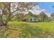 Lush green lawn surrounds this single-story home with dark shutters, offering a serene and spacious outdoor setting at 433 San Salvador Dr, Dunedin, FL 34698