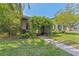 Quaint front entrance featuring a vine-covered archway, a cozy chair, and a welcoming walkway at 433 San Salvador Dr, Dunedin, FL 34698