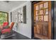 Inviting front porch with wicker seating, and a warm wood door adorned with a decorative wreath at 433 San Salvador Dr, Dunedin, FL 34698
