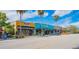 Street view of colorful storefronts with palm trees lining the sidewalk, showcasing local businesses at 433 San Salvador Dr, Dunedin, FL 34698