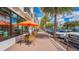Charming sidewalk cafe with tables, orange umbrellas, and views of the street and local establishments at 433 San Salvador Dr, Dunedin, FL 34698