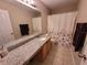 Bathroom with tile flooring, large mirror, granite countertop and floral shower curtain at 4633 White Bay Cir, Wesley Chapel, FL 33545