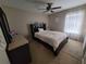 Cozy bedroom with a ceiling fan, window with sheer curtains, and a comfortable bed at 4633 White Bay Cir, Wesley Chapel, FL 33545