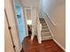 Hallway with wood flooring, a staircase, and access to the laundry room at 4633 White Bay Cir, Wesley Chapel, FL 33545