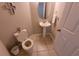 Compact powder room with a pedestal sink and modern fixtures in a neutral color palette at 4633 White Bay Cir, Wesley Chapel, FL 33545