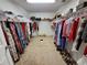 Spacious walk-in closet with rods full of clothes and shoes organized neatly at 4633 White Bay Cir, Wesley Chapel, FL 33545