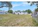 Large backyard with mature trees, lawn, house, and shed, providing a tranquil and versatile outdoor space at 4707 Alma St, New Port Richey, FL 34652