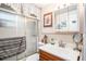 Bright bathroom featuring a vanity with updated fixtures, a decorative mirror, and a tub with a glass enclosure at 4707 Alma St, New Port Richey, FL 34652