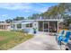 Inviting home exterior features a screened-in porch and adjacent patio seating, perfect for outdoor enjoyment at 4707 Alma St, New Port Richey, FL 34652