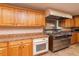 Commercial kitchen featuring stainless steel stove, oven, range hood, and light wood cabinets at 4997 Bostonian Loop, New Port Richey, FL 34655
