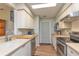 Galley kitchen features white cabinets, modern appliances, and wood-look flooring at 4997 Bostonian Loop # 4997, New Port Richey, FL 34655