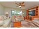 Cozy living room with plush sofas, a ceiling fan, and a large window at 4997 Bostonian Loop, New Port Richey, FL 34655