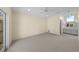 Spacious carpeted bedroom with natural light, ceiling fan, and adjacent vanity area at 5290 White Sand Ne Cir, St Petersburg, FL 33703